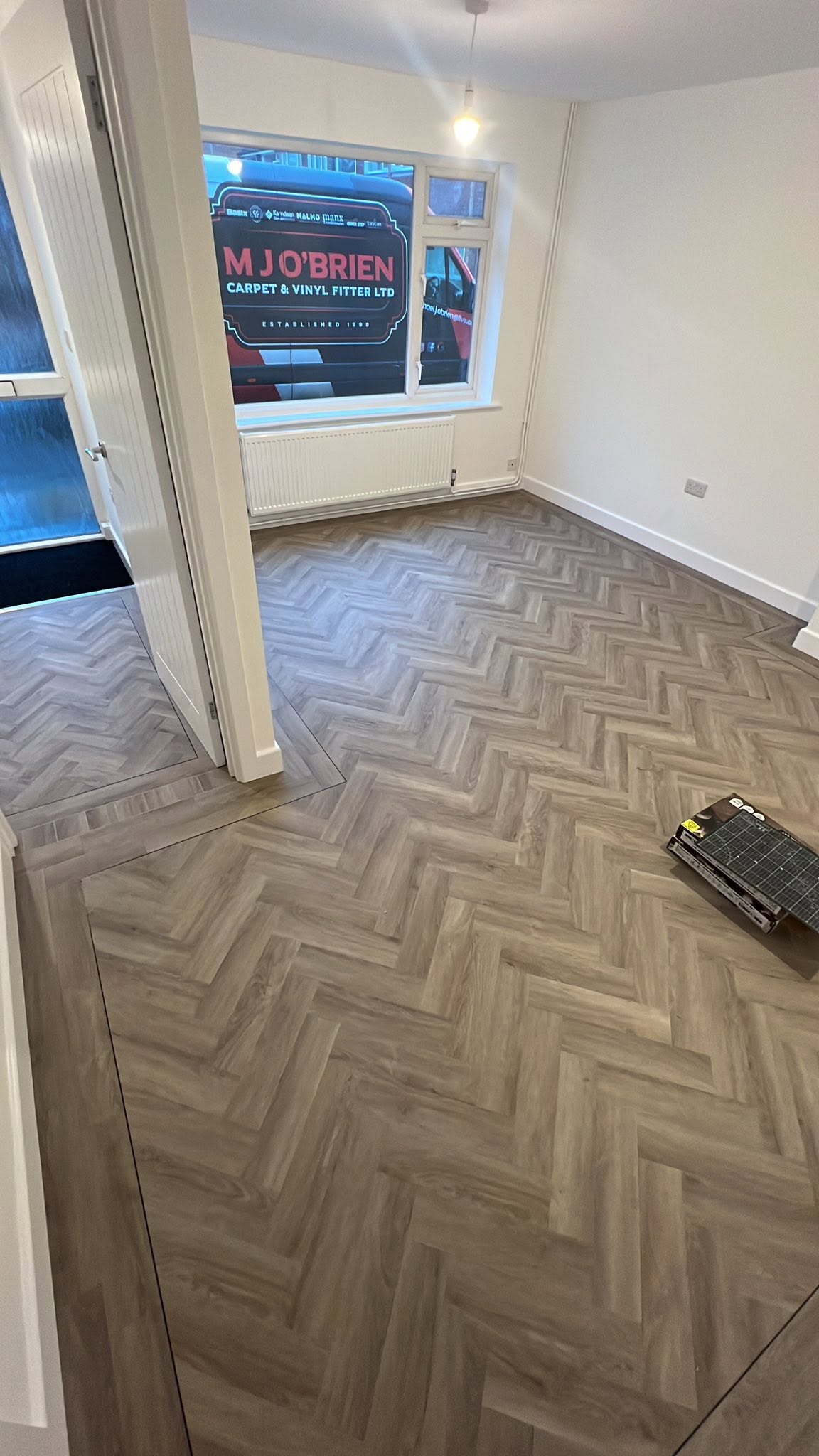 Empty front room with a herringbone floor