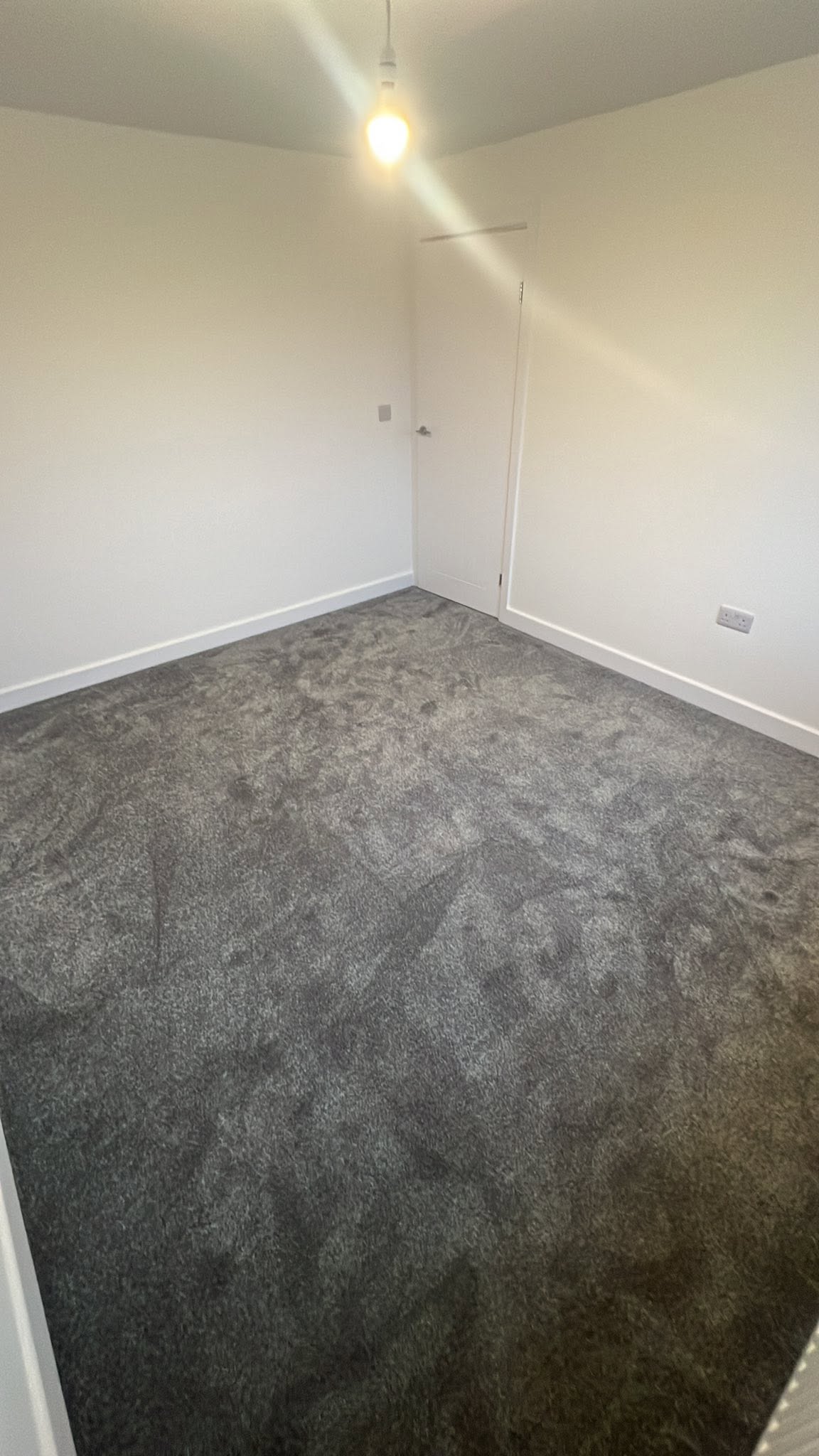 Charcoal carpet fitted in an empty bedroom