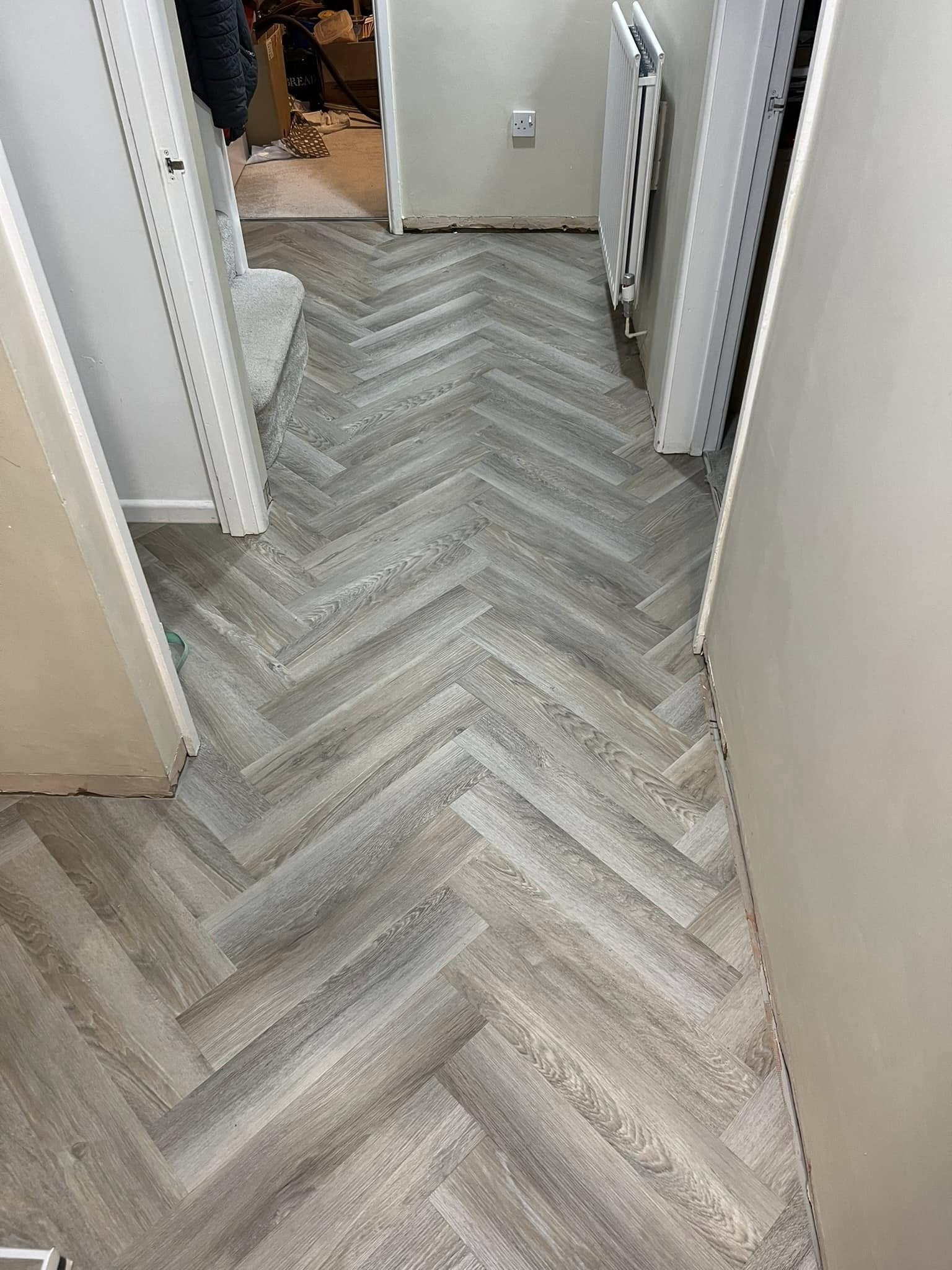Grey herringbone floor down a hallway