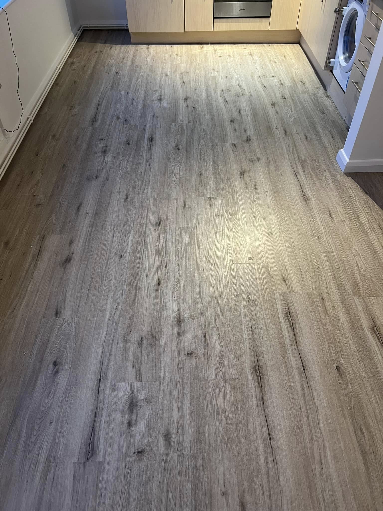 Grey oak-effect plank floor in a kitchen and utility