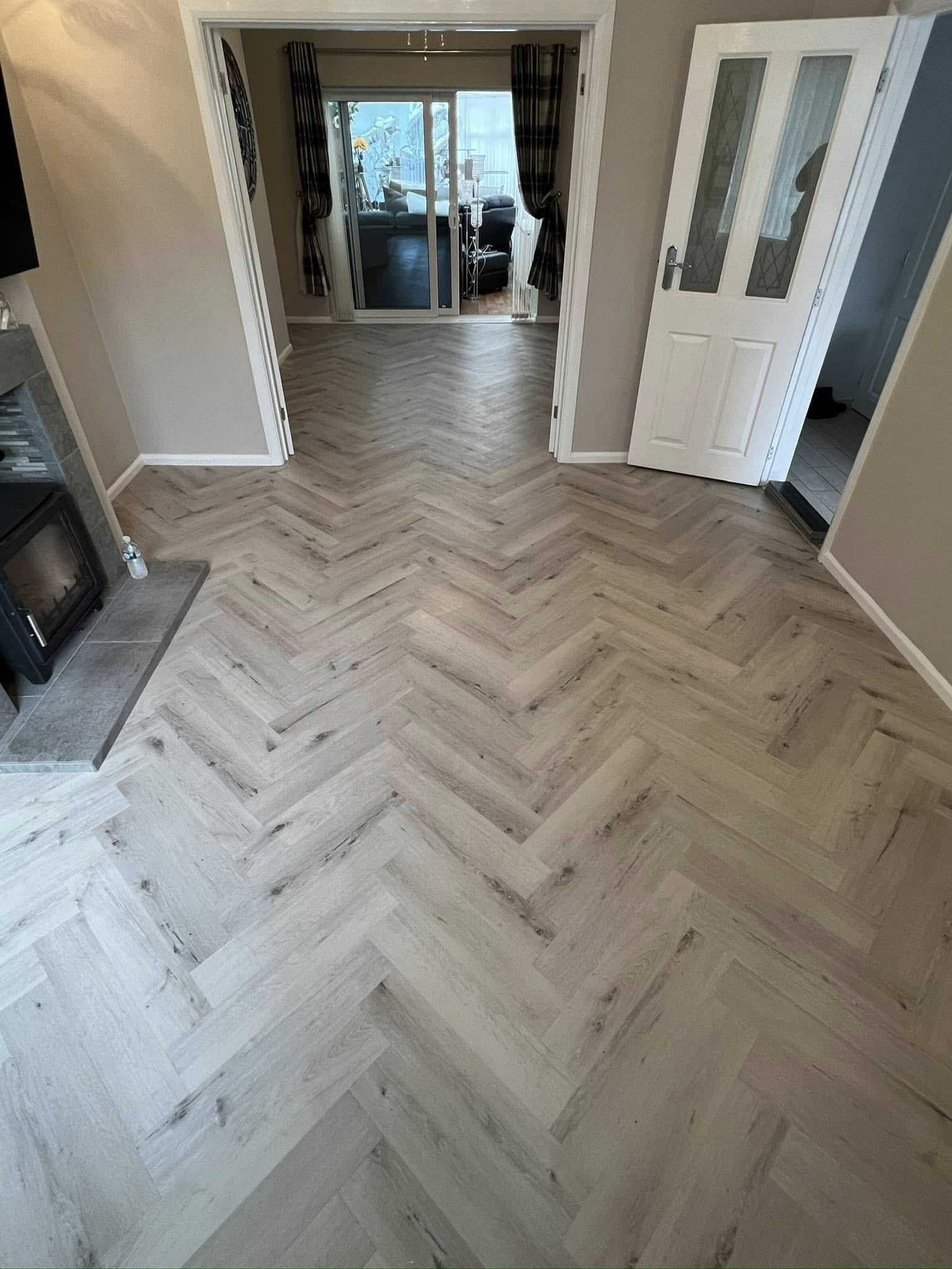 Grey herringbone running through an open-plan room to a conservatory