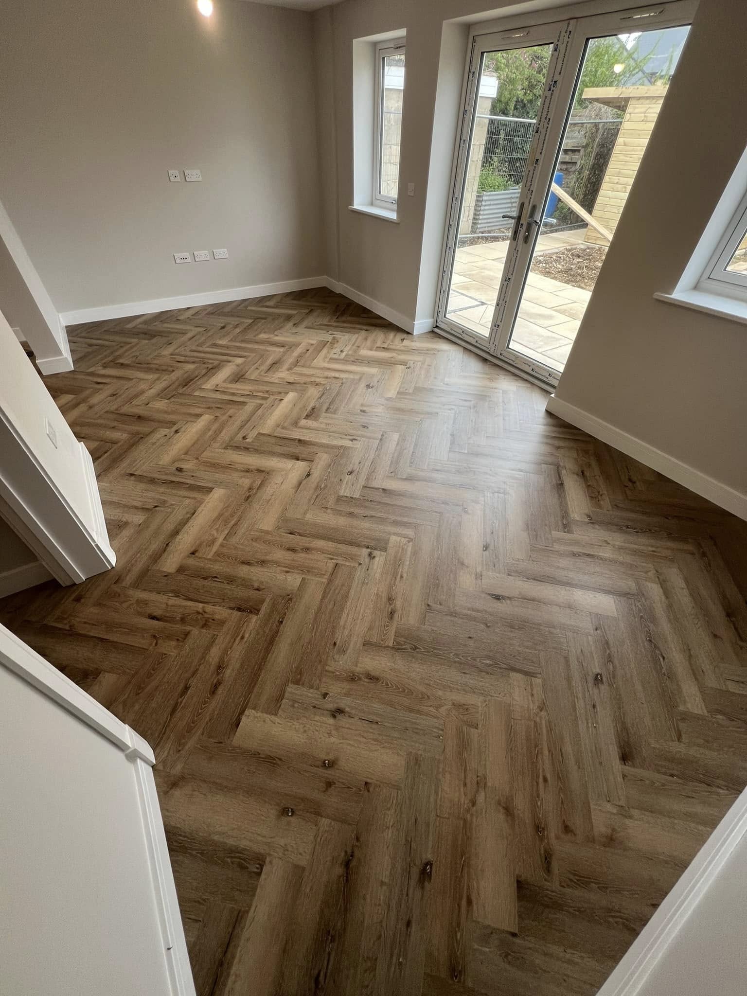 Rich oak herringbone in a living room with French doors