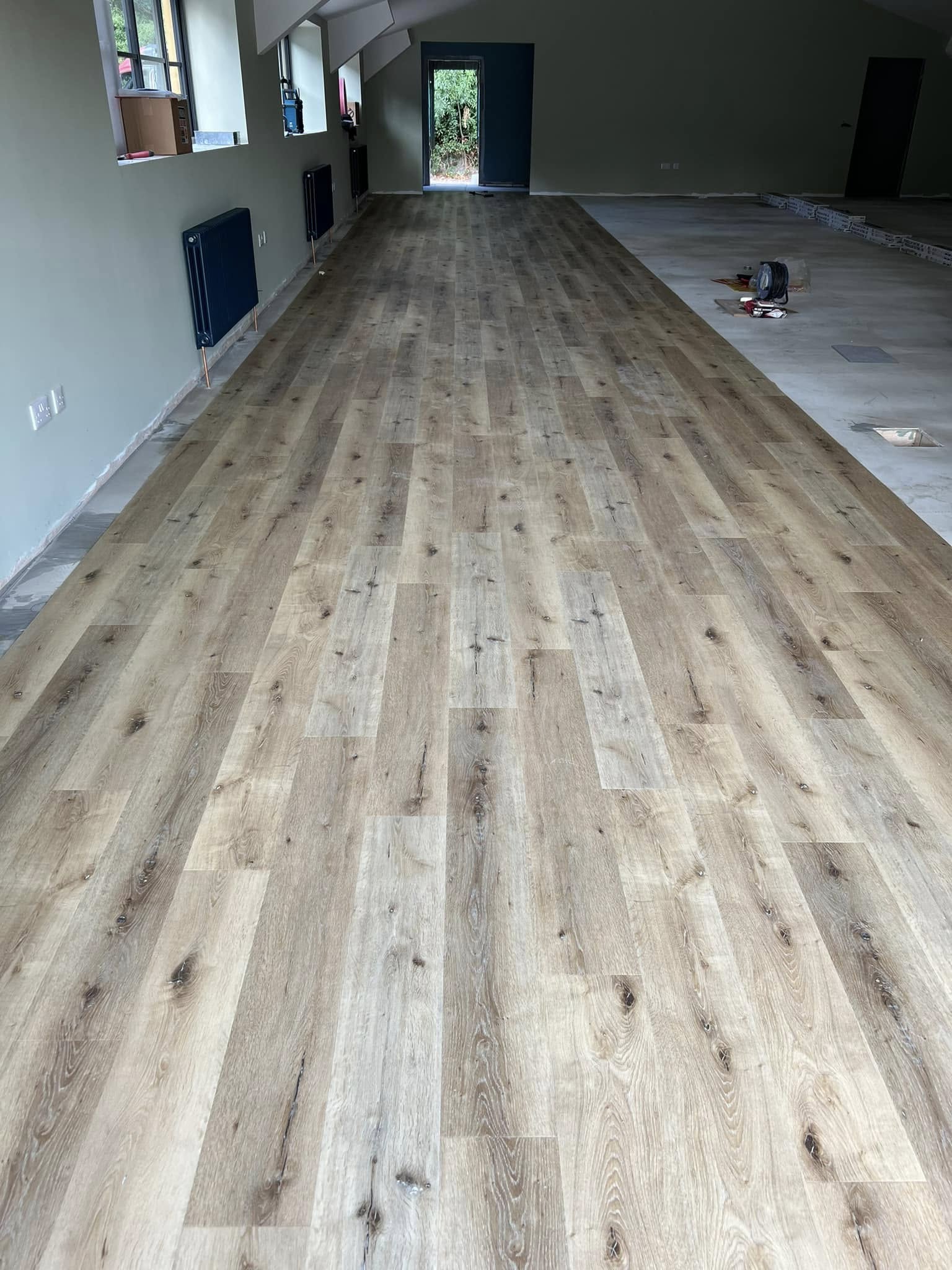 Finished oak-effect plank LVT down the length of a long room