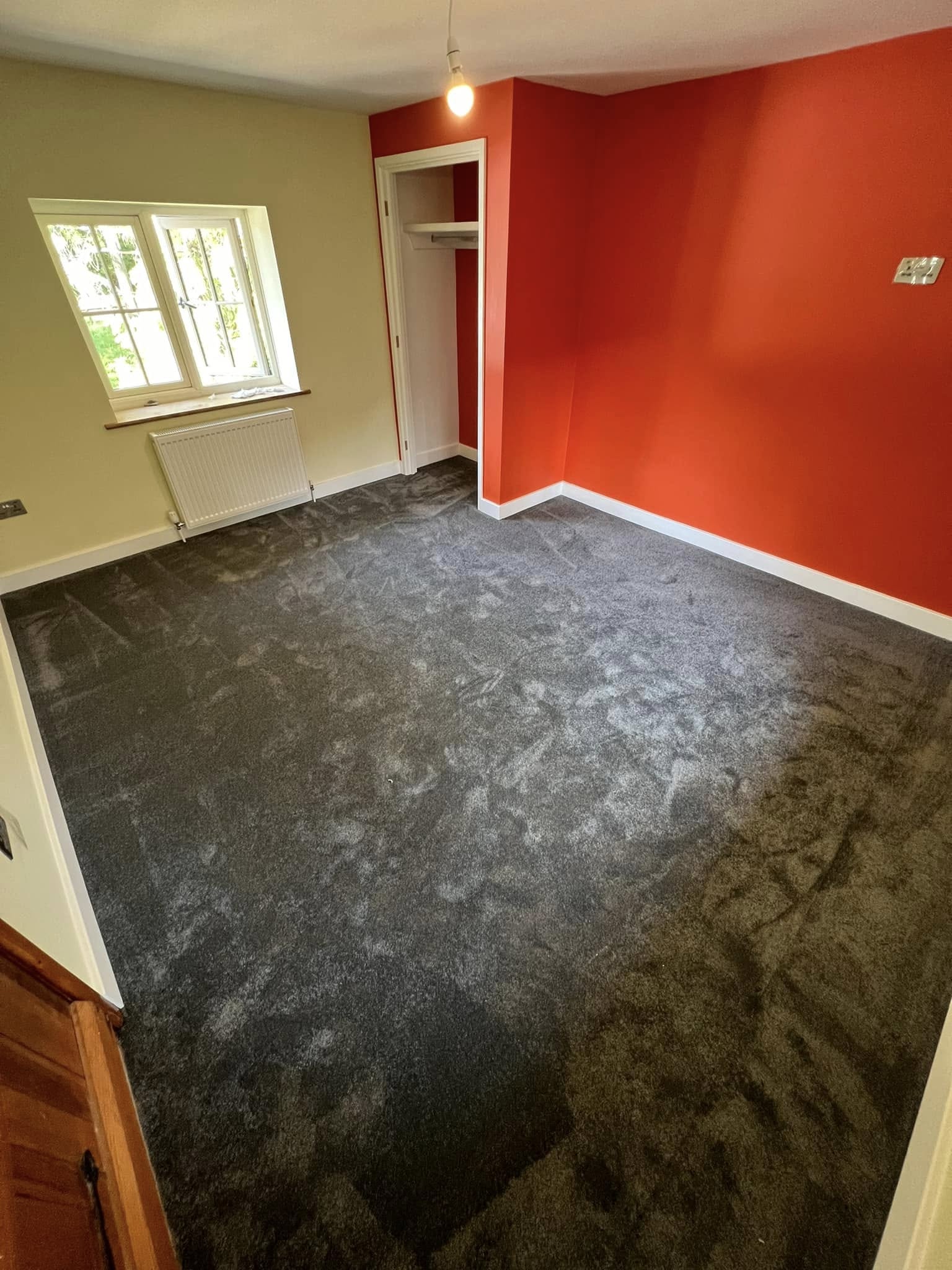 Charcoal carpet in a room with an orange feature wall