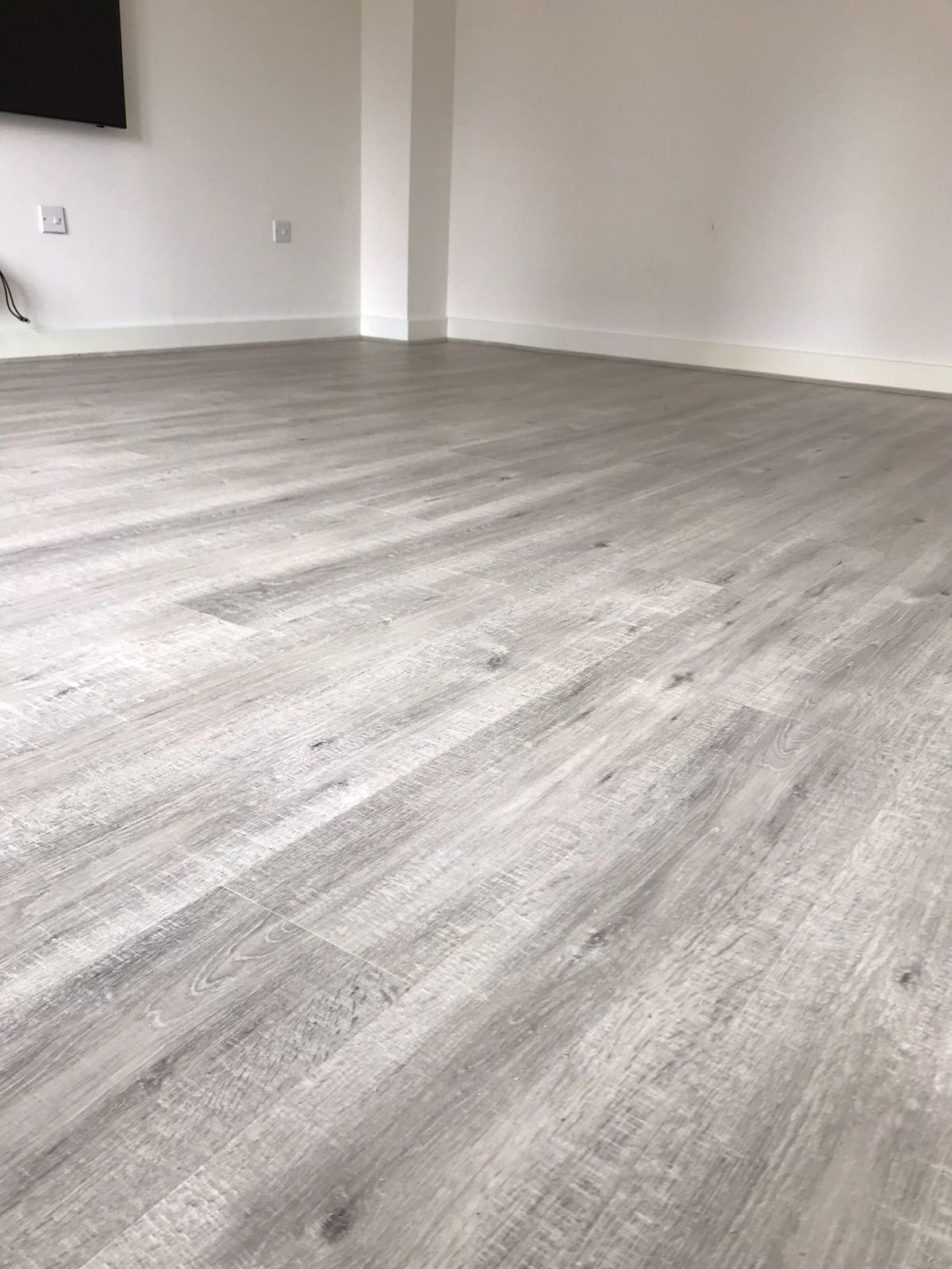 Grey wood-effect plank floor in an empty room